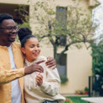 A man and woman who recently formed a domestic partnership stand in front of their condo building. Registered domestic partners in California enjoy nearly identical rights and responsibilities to those who are married.