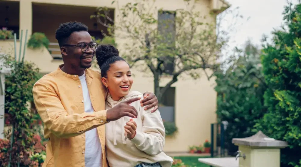 A man and woman who recently formed a domestic partnership stand in front of their condo building. Registered domestic partners in California enjoy nearly identical rights and responsibilities to those who are married.