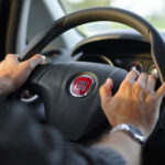 alt text: A volunteer driver helping a senior into a car.