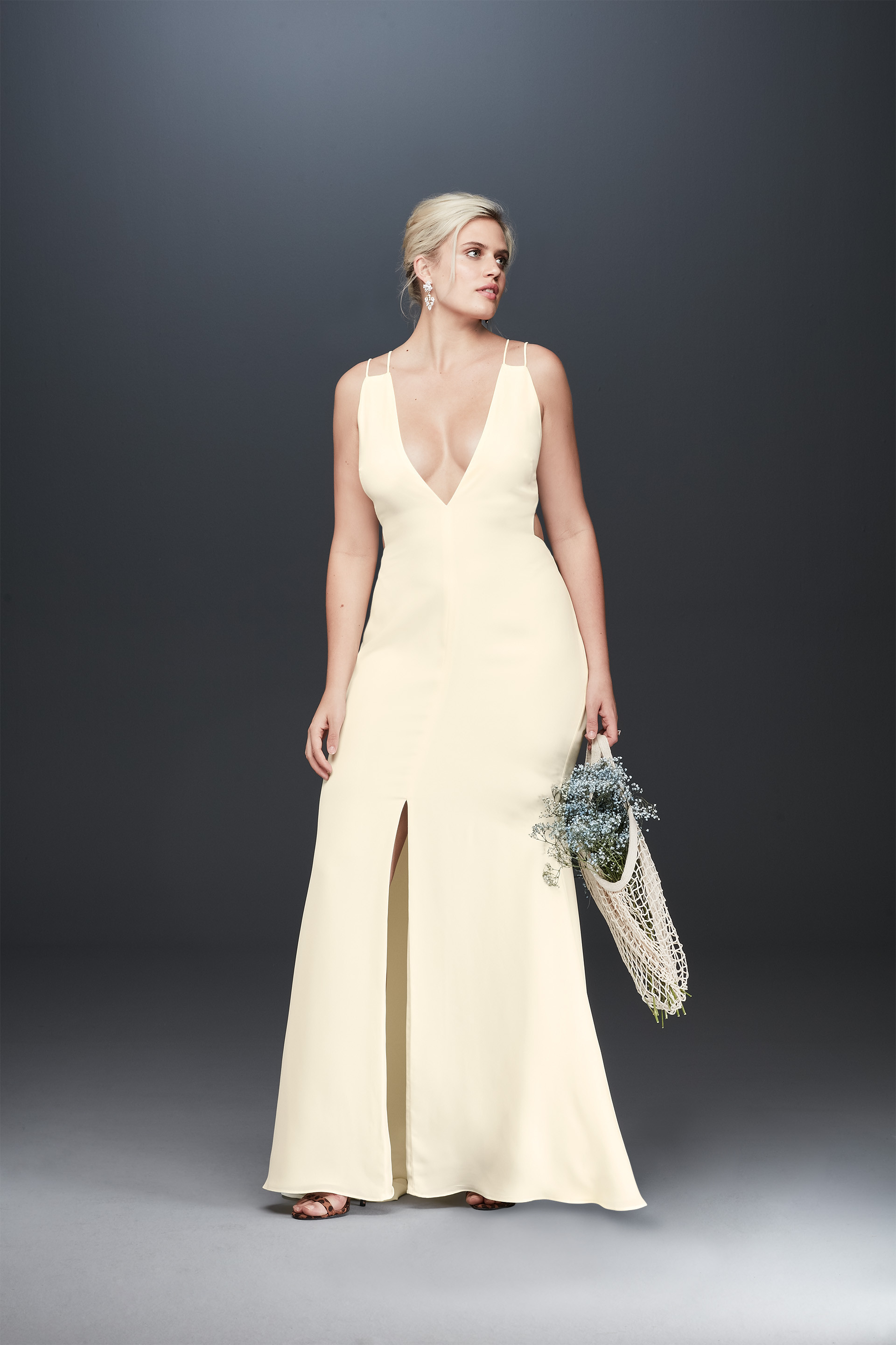 Bride looking away in double strap plunging neckline wedding dress, Fame and Partners stylish bridal wear