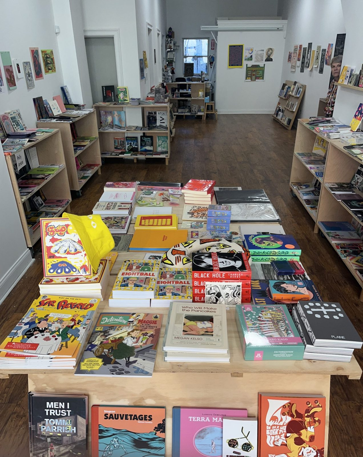 alt text: interior of partners and son comic shop with bookshelves and art on the walls