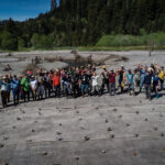 Aerial view of people standing in a circle in a redwood forest, highlighting collaborative partnerships in conservation efforts