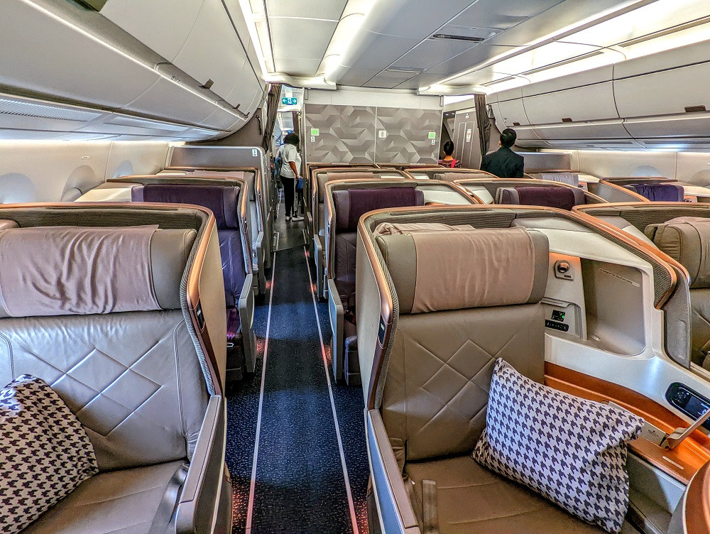 Interior view of Singapore Airlines Business Class cabin on SQ24, emphasizing spacious seating and premium ambiance.