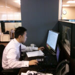 alt text: Wabash College student Weijie Shi working in the office at his summer internship.