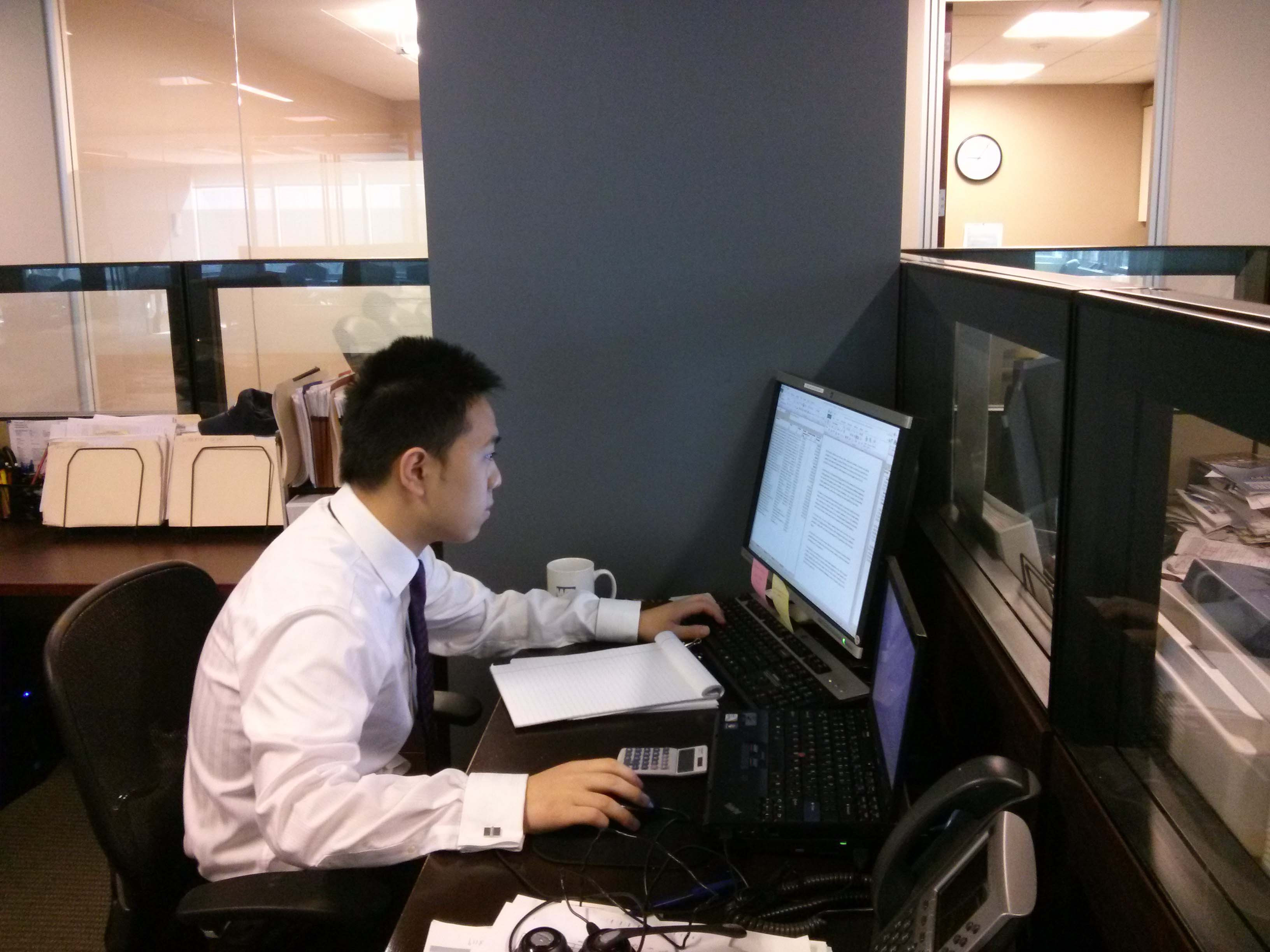 alt text: Wabash College student Weijie Shi working in the office at his summer internship.