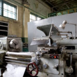 A vintage metal working machine in a warehouse.