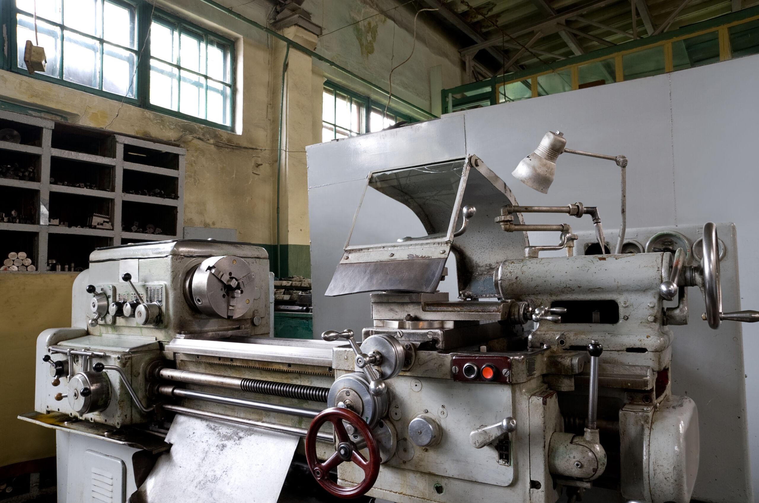 A vintage metal working machine in a warehouse.
