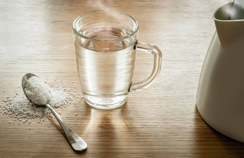 Person rinsing their mouth with salt water, a home remedy for relieving wisdom teeth-related headaches