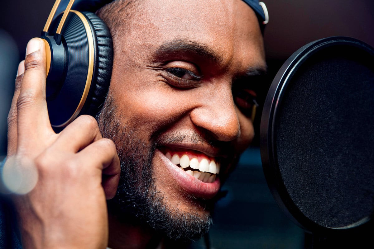 Person recording audio in a home studio