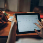 Businesswoman on tablet scheduling on her calendar