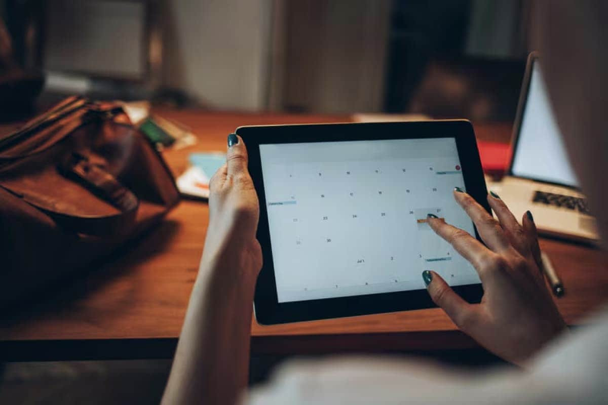 Businesswoman on tablet scheduling on her calendar