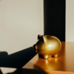 Golden piggy bank in front of white background.