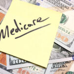 Senior woman with a healthcare professional discussing Medicare plans medicare-and-cash-IS-1202330455