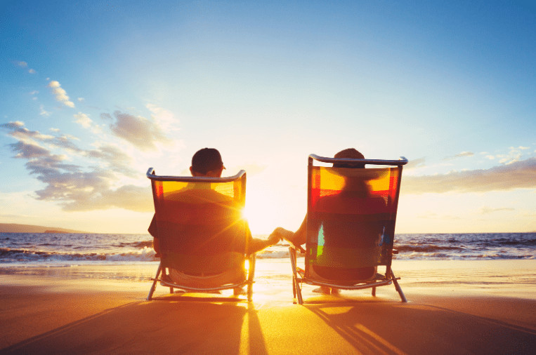 Retired couple sitting on a bench, enjoying their investment income