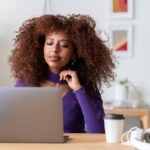 A person sitting at a table with a laptop.