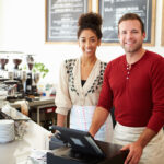 Gig worker using laptop in a cafe
