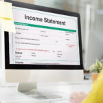 A business professional analyzing a single step income statement to identify areas for revenue growth and cost reduction