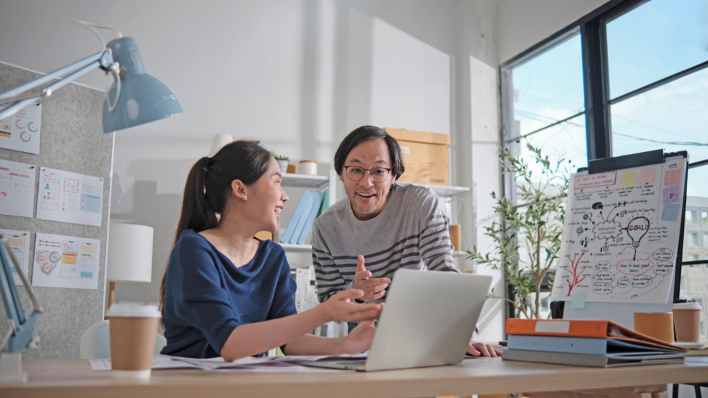 Two people at a desk are collaborating on their dropshipping business, showing teamwork and focus.