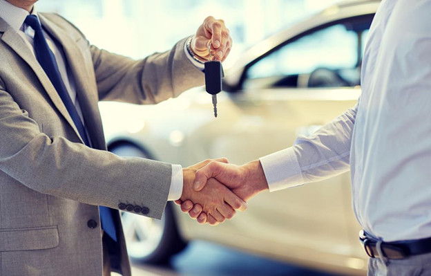 A person signing car loan documents to acquire the car