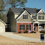 House with a SOLD sign in front of it, indicating success in property sales and real estate investments
