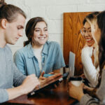A diverse group of people collaborating and discussing financial plans, highlighting the importance of community support and professional guidance in achieving homeownership